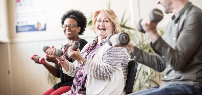 Rehab group smiling lifting weights